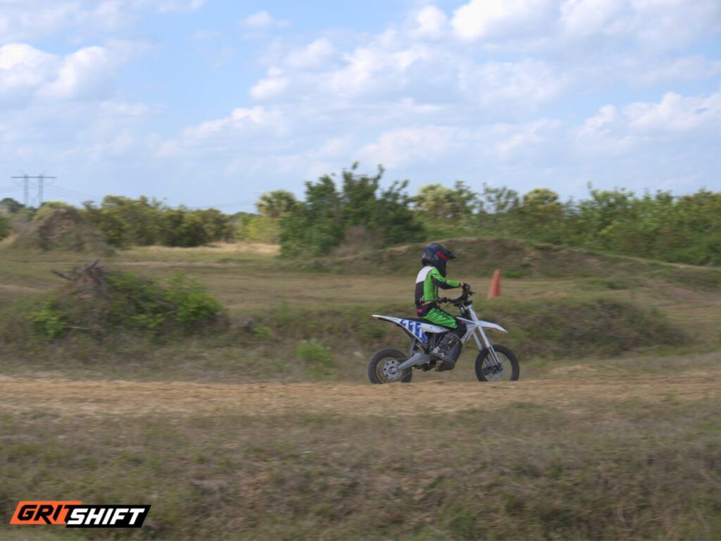 A kid on an electric dirt bike on a track 