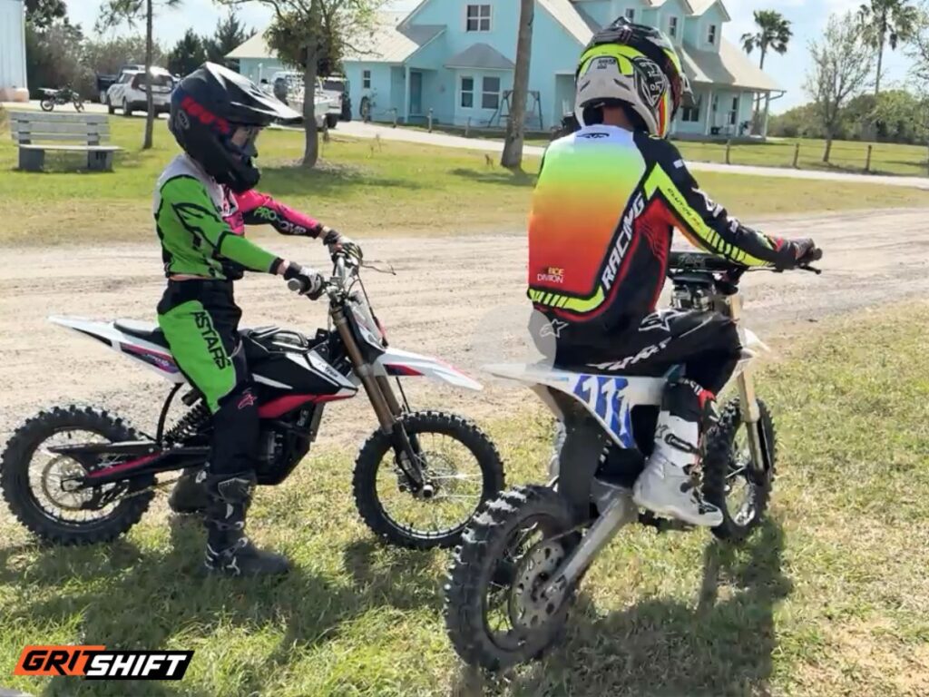 2 kids riding electric dirt bikes in full gear